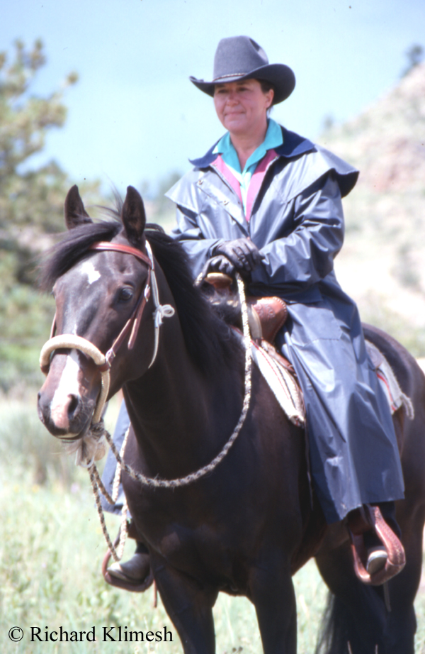 Cherry Hill mounted on Quarter Horse Zipper while wearing a slicker