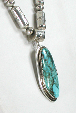 Graduated Stamped sterling silver barrel bead necklace 26 inches long with turquoise pendant